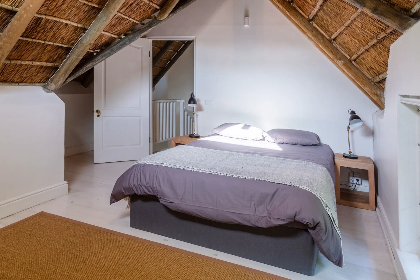 Candlewood Cottage, a thatched holiday villa in St. Francis Bay nestled among Candlewood trees. A serene self-catering retreat sleeping up to 8 guests, featuring elegant, pared-down interiors, a cosy loft with its own TV and kitchenette, and easy access to canals and the beach.