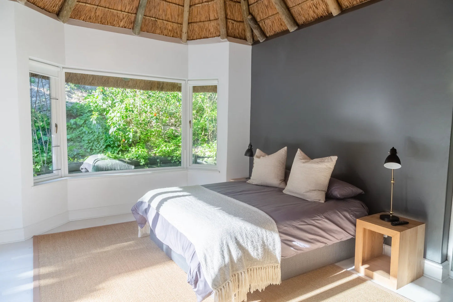 Candlewood Cottage, a thatched holiday villa in St. Francis Bay nestled among Candlewood trees. A serene self-catering retreat sleeping up to 8 guests, featuring elegant, pared-down interiors, a cosy loft with its own TV and kitchenette, and easy access to canals and the beach.