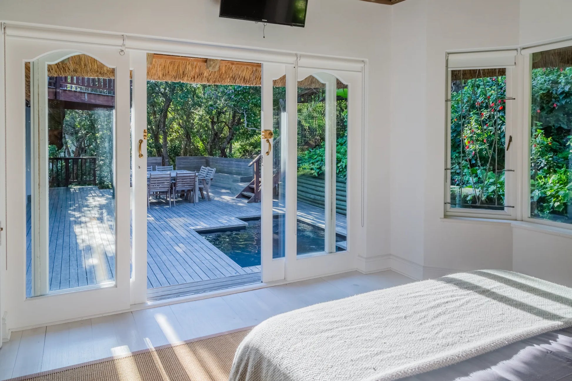 Candlewood Cottage, a thatched holiday villa in St. Francis Bay nestled among Candlewood trees. A serene self-catering retreat sleeping up to 8 guests, featuring elegant, pared-down interiors, a cosy loft with its own TV and kitchenette, and easy access to canals and the beach.