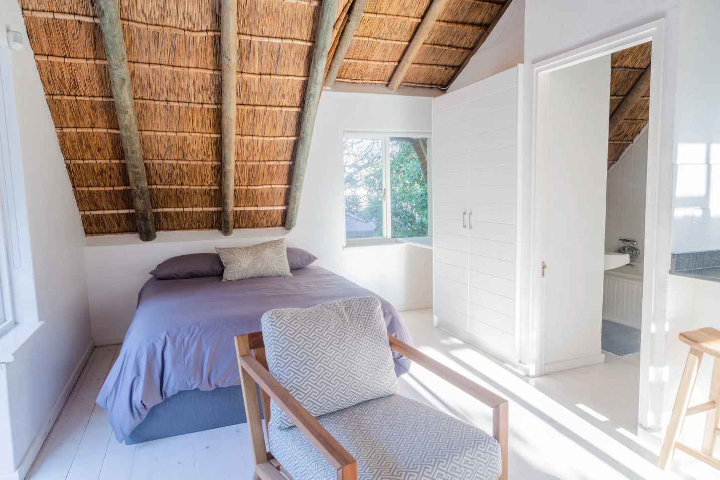 Candlewood Cottage, a thatched holiday villa in St. Francis Bay nestled among Candlewood trees. A serene self-catering retreat sleeping up to 8 guests, featuring elegant, pared-down interiors, a cosy loft with its own TV and kitchenette, and easy access to canals and the beach.