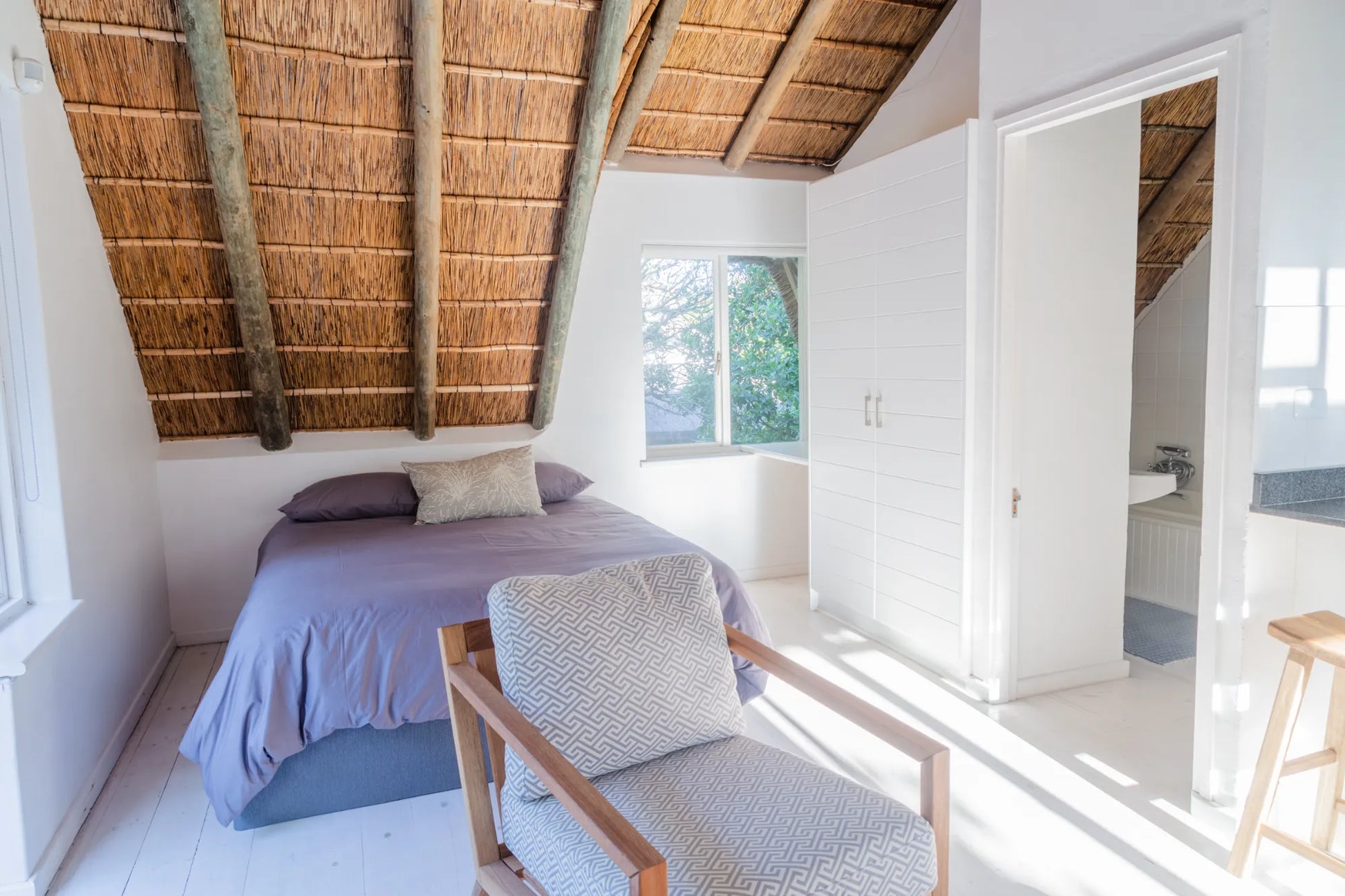 Candlewood Cottage, a thatched holiday villa in St. Francis Bay nestled among Candlewood trees. A serene self-catering retreat sleeping up to 8 guests, featuring elegant, pared-down interiors, a cosy loft with its own TV and kitchenette, and easy access to canals and the beach.
