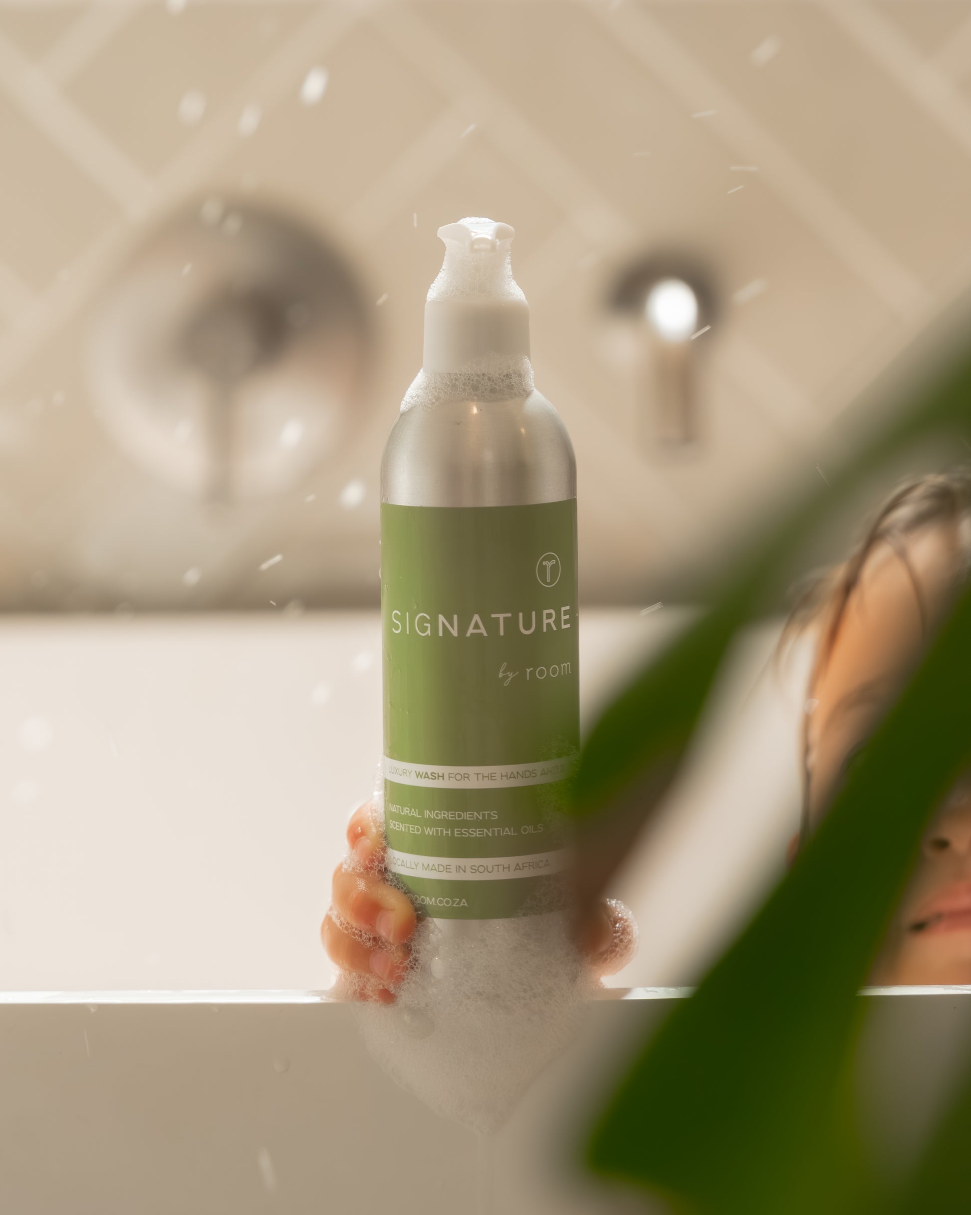 sigNATURE Wash creating soft, fragrant bubbles in a warm bath. Made with natural ingredients and pure essential oils, this luxurious, locally made formula transforms into a soothing bubble bath — gentle, moisturizing, and free from SLS, parabens, and palm oil.