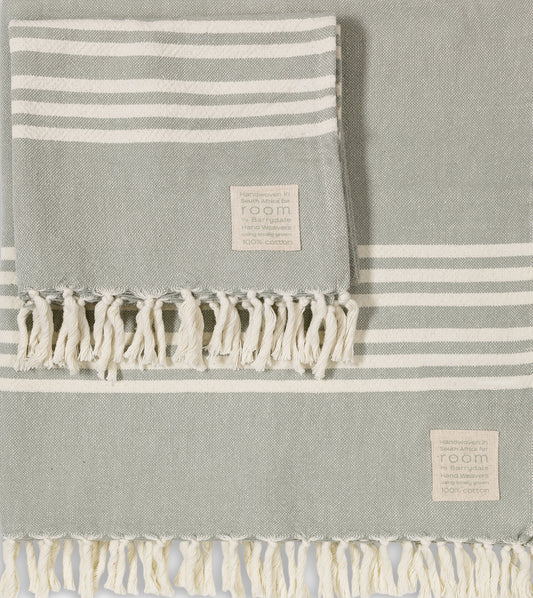 The Barrydale Hand Weavers' 100% Cotton Hand Towel in The Room Key's&nbsp;green and grey is a handwoven textile crafted from 100% locally sourced, unbleached cotton. Measuring approximately 85cm in width and 160cm in length, this towel offers ample coverage for various uses.