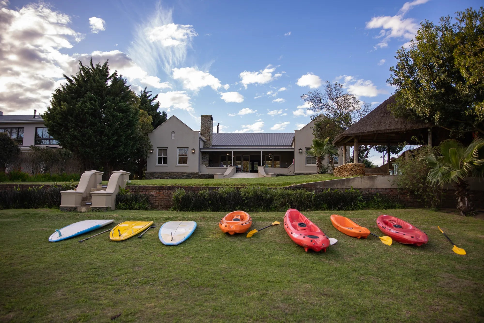 Peacehaven Cottage, a luxurious holiday home on the banks of the Breede River with a grand farmhouse feel. The property includes a spacious Manor House sleeping 8 guests and two stylishly converted Boat Sheds, each accommodating 2 guests.