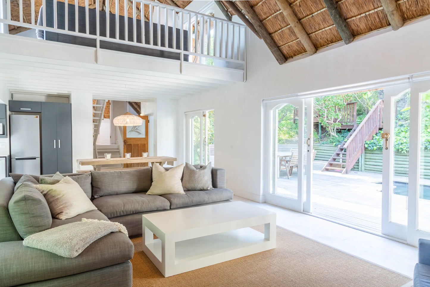 Candlewood Cottage, a thatched holiday villa in St. Francis Bay nestled among Candlewood trees. A serene self-catering retreat sleeping up to 8 guests, featuring elegant, pared-down interiors, a cosy loft with its own TV and kitchenette, and easy access to canals and the beach.