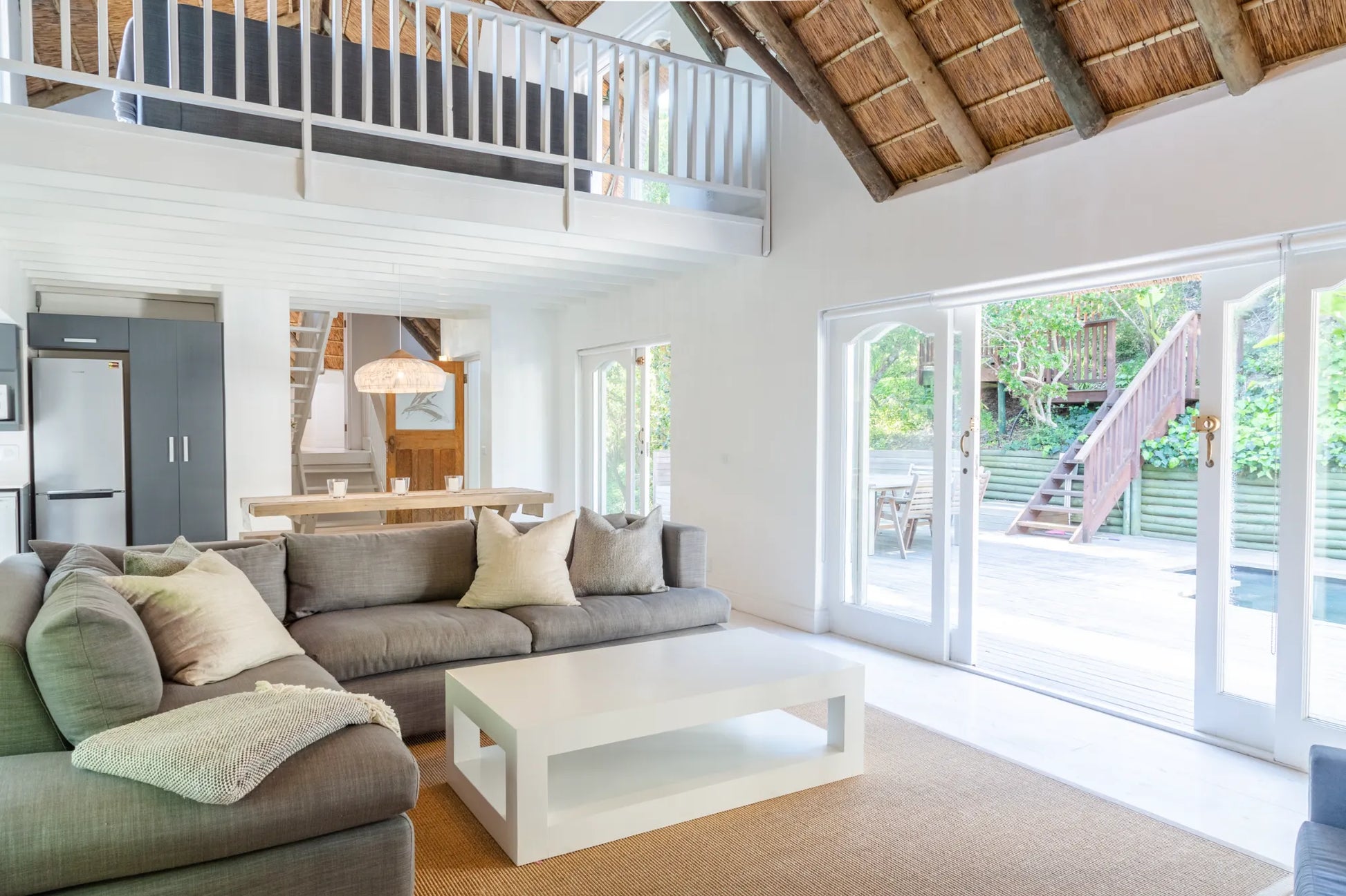 Candlewood Cottage, a thatched holiday villa in St. Francis Bay nestled among Candlewood trees. A serene self-catering retreat sleeping up to 8 guests, featuring elegant, pared-down interiors, a cosy loft with its own TV and kitchenette, and easy access to canals and the beach.