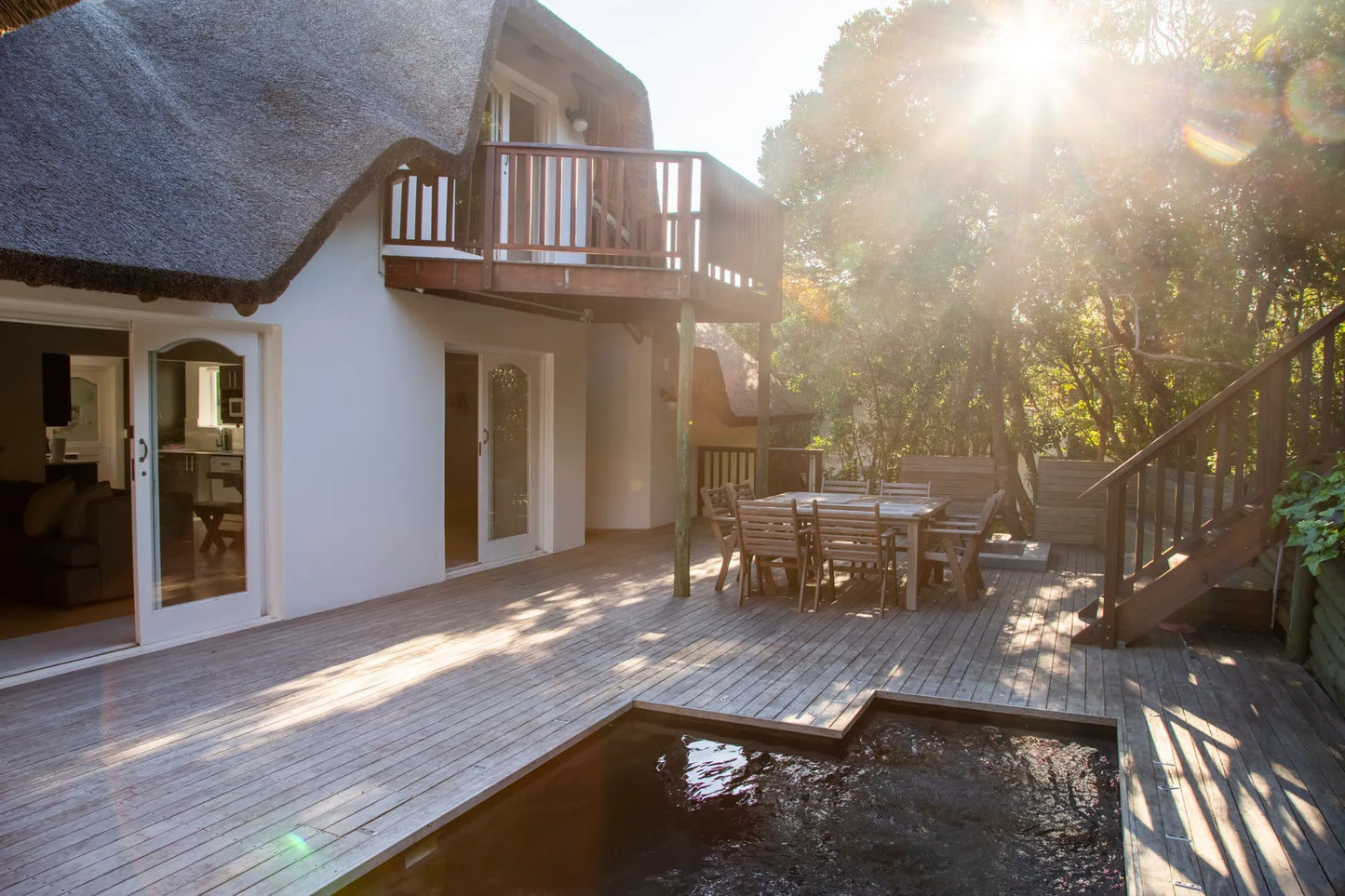 Candlewood Cottage, a thatched holiday villa in St. Francis Bay nestled among Candlewood trees. A serene self-catering retreat sleeping up to 8 guests, featuring elegant, pared-down interiors, a cosy loft with its own TV and kitchenette, and easy access to canals and the beach.