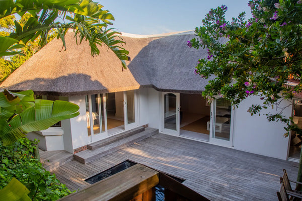Candlewood Cottage, a thatched holiday villa in St. Francis Bay nestled among Candlewood trees. A serene self-catering retreat sleeping up to 8 guests, featuring elegant, pared-down interiors, a cosy loft with its own TV and kitchenette, and easy access to canals and the beach.